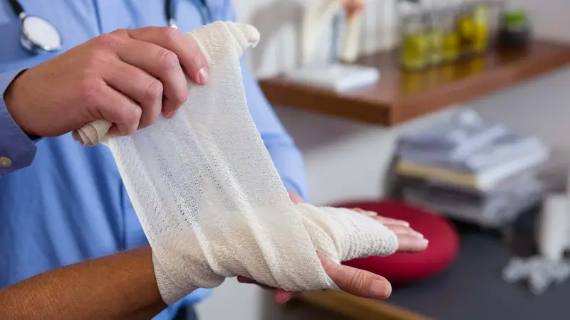 Bandage applied to an injured hand during first aid training Assured First Aid Wiltshire